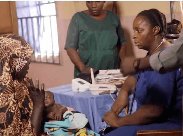 A nurse examines a young child with a stethoscope in a DOGO partner clinic while the child's mother watches.